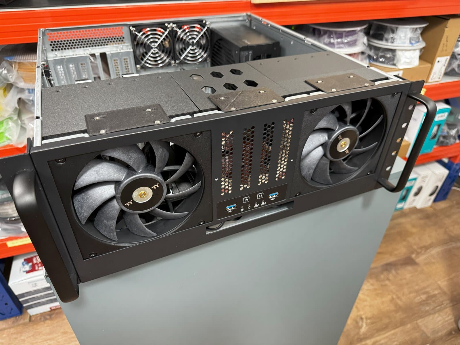 Custom 3D printed high-density hard drive cages installed behind large front intake fans in a short-depth rack server.